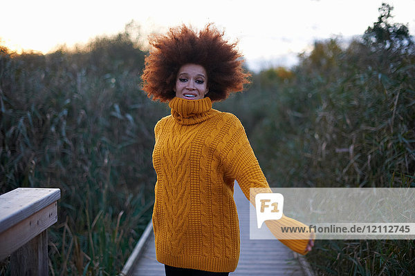 Portrait of young woman walking along rural pathway