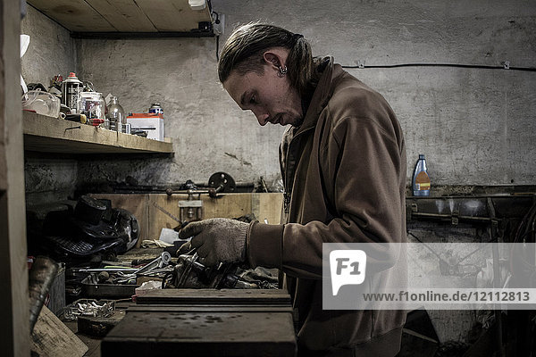 Mechanic working at workshop bench
