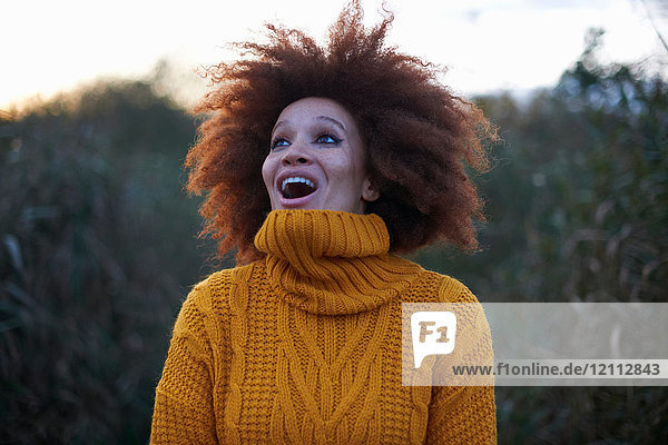 Young woman in rural setting  looking up with excited expression