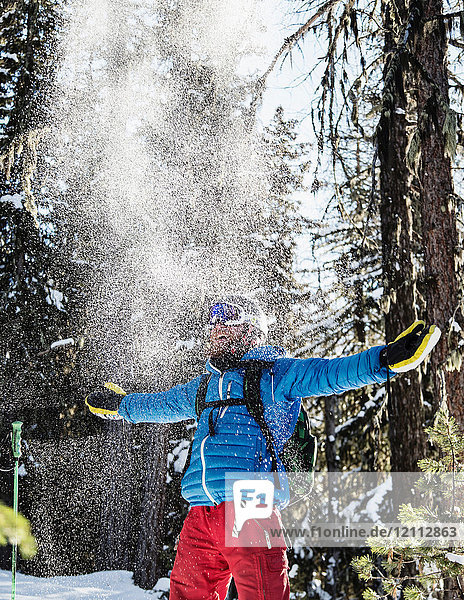 Portrait of skier  celebrating in snow