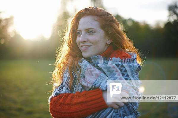 Young woman in rural setting  wrapped in blanket