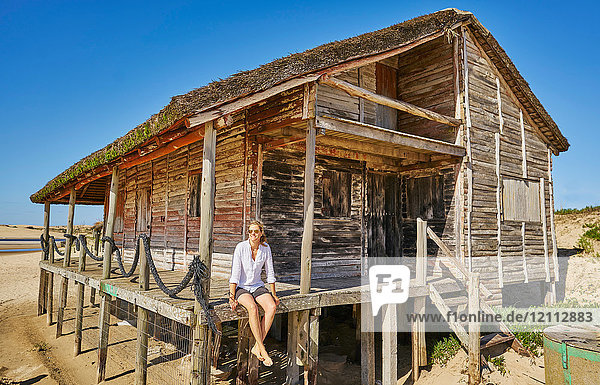 Frau auf der Veranda einer Holzhütte schaut weg  Polonio  Rocha  Uruguay  Südamerika