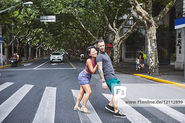 Woman pushing boyfriend on pedestrian crossing  Shanghai French Concession  Shanghai  China