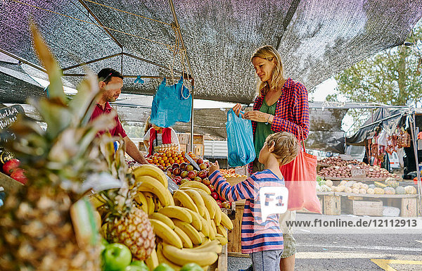Mutter und Söhne kaufen am Obst- und Gemüsestand auf dem Markt ein  Montevideo  Uruguay  Südamerika