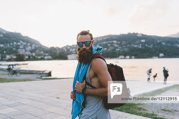 Portrait of young male hipster with backpack at lake Como  Lombardy  Italy