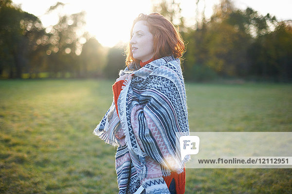 Young woman in rural setting  wrapped in blanket