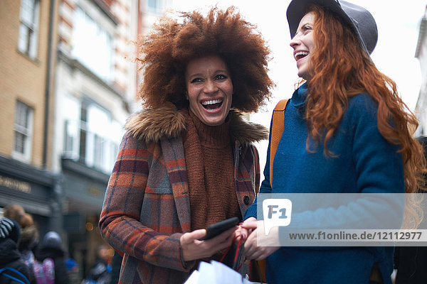 Two young women in street  laughing