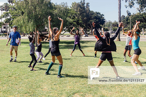 Schulmädchen-Fussballspielerinnen wärmen sich auf dem Schulsportplatz auf