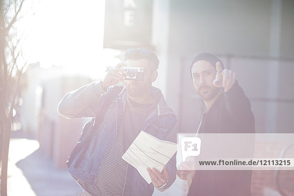 Zwei Männer auf der Straße  mittlerer erwachsener Mann schaut durch die Kamera  junger Mann zeigt nach vorne