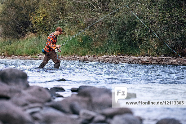 Man wading in river  fishing