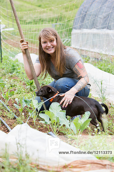 Frau mit Hund im Gemüsegarten
