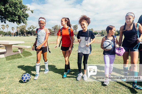 Schulmädchen gehen zum Fußballtraining auf dem Schulsportplatz