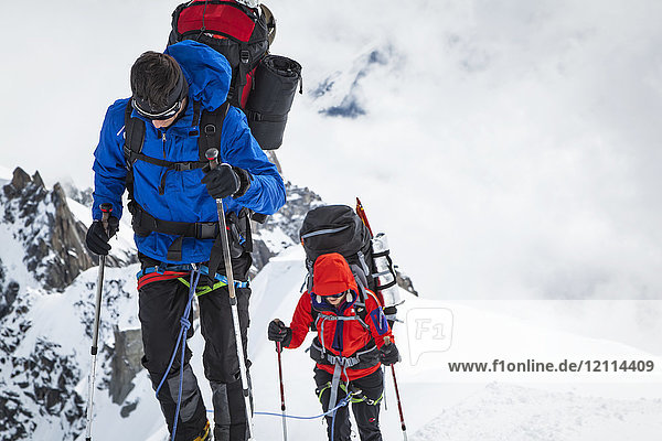 Bergsteiger mit Ausrüstung auf einem verschneiten Grat  Aiguille du midi; Chamonix-Mont-Blanc  Haute-Savoie  Frankreich