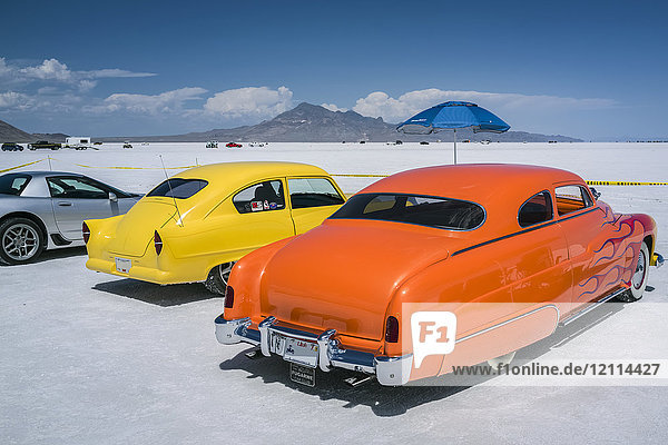 Individuell gestaltete Zuschauerfahrzeuge bei der Bonneville Speed Week auf den Bonneville Salt Flats. Gelber Henry J und Mercury Coupe mit Flammen  beide aus den frühen 1950er Jahren; Wendover  Utah  Vereinigte Staaten von Amerika