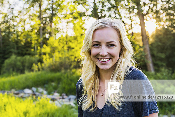 Portrait of a young woman with long blond hair in a park in autumn; Edmonton  Alberta  Canada