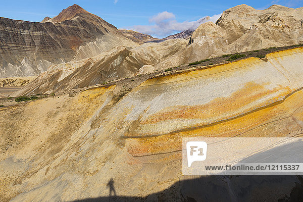 A photographer catches his shadow in a colorful canyon near the base of the ash-covered Knife Creek Glaciers in the Valley of Ten Thousand Smokes in Katmai National Park; Alaska United States of America
