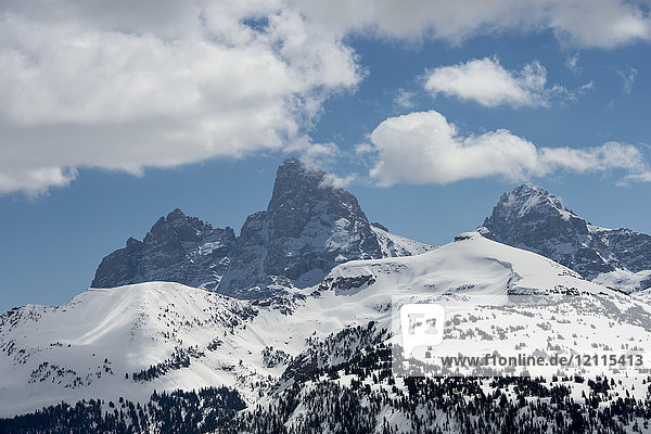 Schroffe Berggipfel in einer verschneiten Landschaft mit blauem Himmel und Wolken  Peace Park; Wyoming  Vereinigte Staaten von Amerika