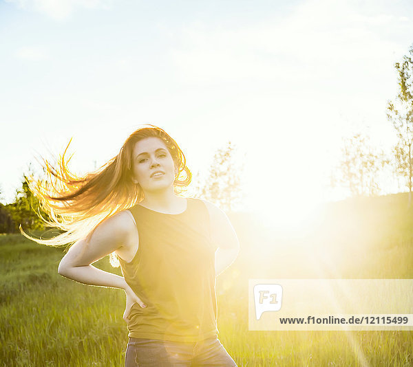 Porträt einer jungen Frau  deren langes Haar hinter ihr weht und neben der eine Sonnenfackel leuchtet; Edmonton  Alberta  Kanada