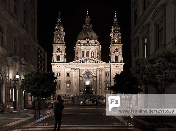 Die nächtlich beleuchtete St. Stephans-Basilika mit Fußgängern auf der Straße; Budapest  Budapest  Ungarn