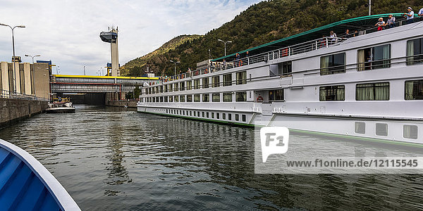 A tour boat cruises by the Iron Gate Hydroelectric Power Station  the largest dam on the Danube river and one of the largest hydro power plants in Europe; Drobeta-Turnu Severin  Jude?ul Mehedin?i  Serbia