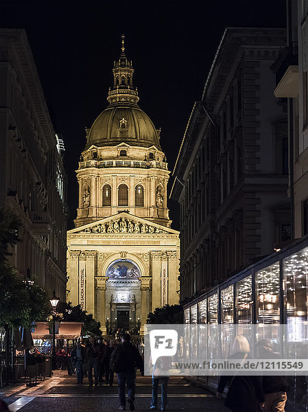 Die nächtlich beleuchtete St. Stephans-Basilika mit Fußgängern auf der Straße; Budapest  Budapest  Ungarn