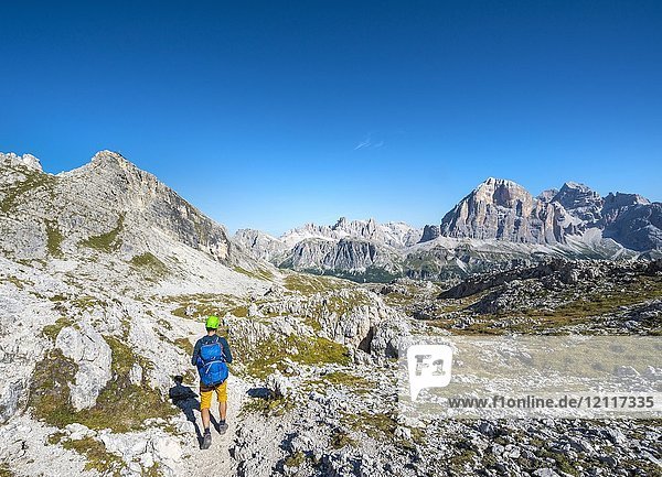 Hiker with climbing helmet on footpath to the Nuvolau  view of the Nuvolau summit and mountain range Tofane  Dolomites  South Tyrol  Trentino-Alto Adige  Italy  Europe