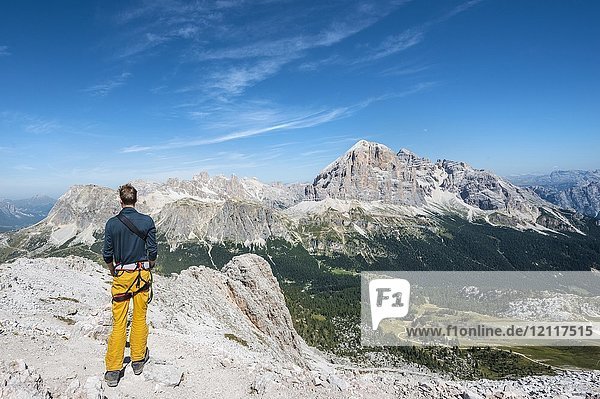 Hiker on the summit of the Averau  view towards the Falzarego Pass and peaks Tofane and Lagazuoi  Dolomites  South Tyrol  Trentino-Alto Adige  Italy  Europe