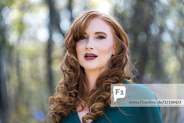 Portrait of a 27 year old redhead woman outdoors.