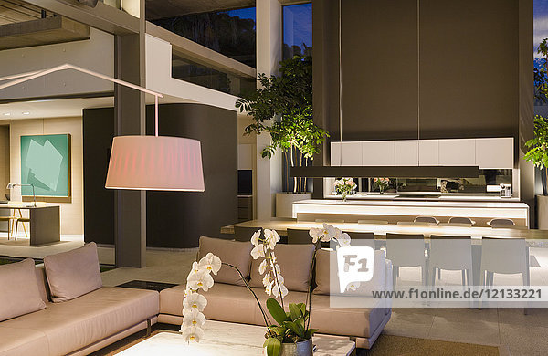 Beleuchtetes modernes  luxuriöses Wohnhaus mit Wohnzimmer und Küche