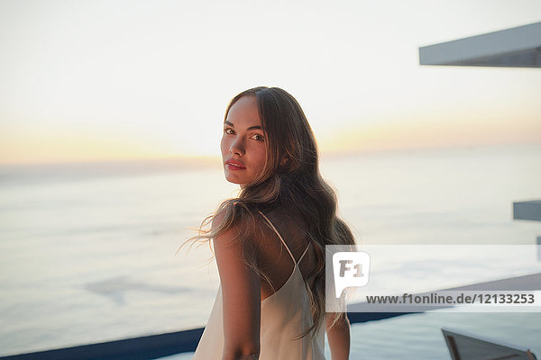 Porträt ernst  schöne Frau auf Luxus-Terrasse mit Blick auf den Sonnenuntergang Meer