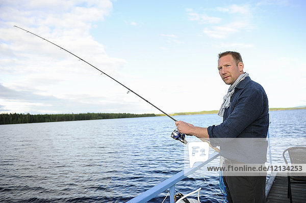 Mann beim Angeln vor dem Pier in Medelpad Schweden