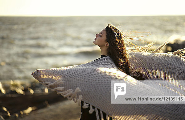 Wind weht Schal der kaukasischen Frau am Strand
