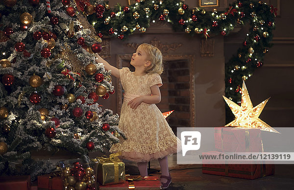 Caucasian girl decorating Christmas tree