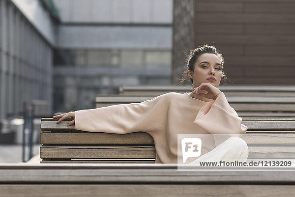 Porträt einer nachdenklichen kaukasischen Frau  die auf einer Bank in der Stadt sitzt