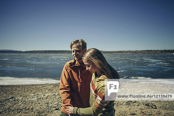 Kaukasisches Paar hält Hände am Strand