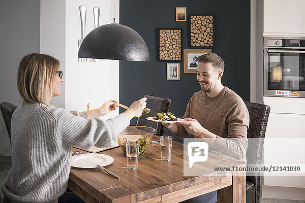 Couple eating salad at dining table at home