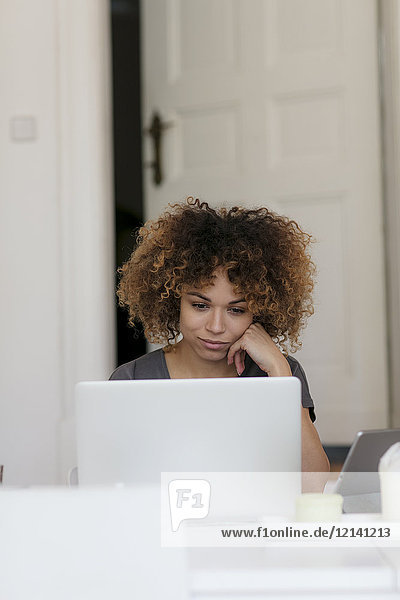 Young woman at home using laptop