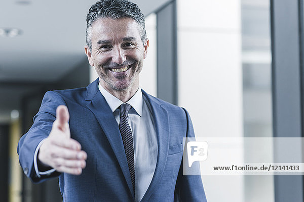 Portrait of smiling businessman about to shake hands