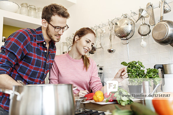 Fröhliches junges Paar beim gemeinsamen Kochen in der Küche