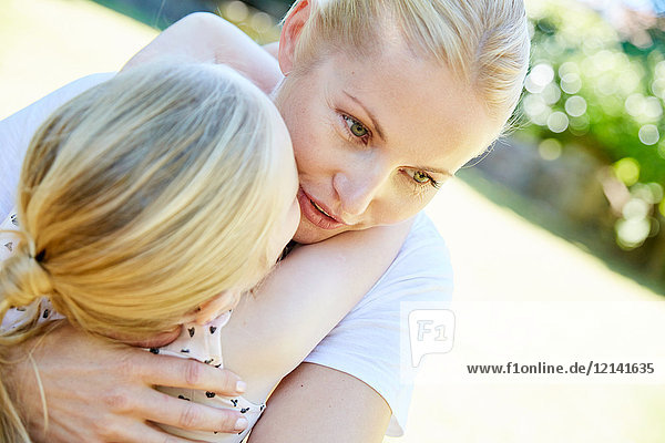 Tochter und Mutter umarmen sich im Freien