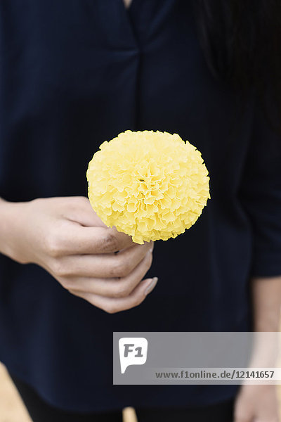 Nahaufnahme einer Frau mit einer gelben Blume