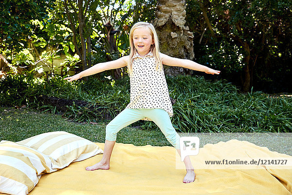 Mädchen beim Yoga auf einer Decke