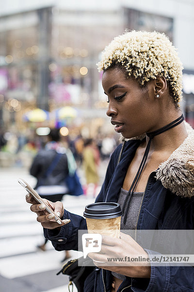 USA  New York City  Portrait einer jungen Frau mit Kaffee zum Mitnehmen