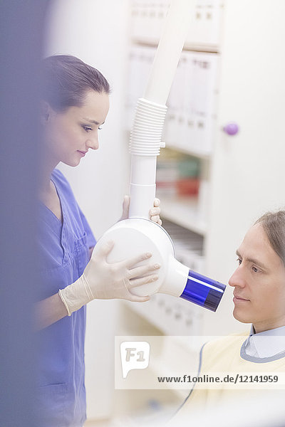 Zahnärztin macht Röntgenbild eines Patienten