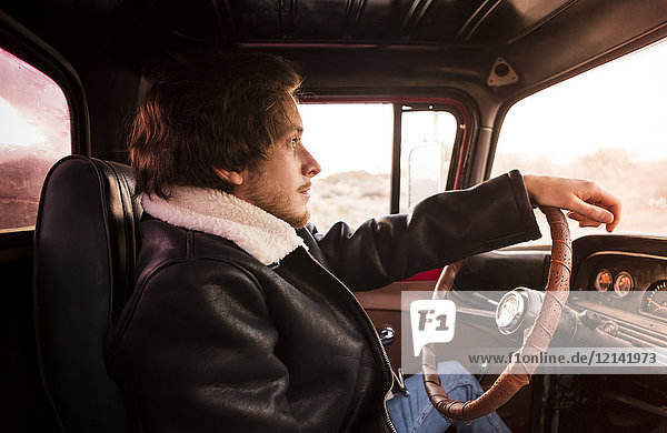 USA  California  Joshua Tree  young man sitting in an pick-up truck