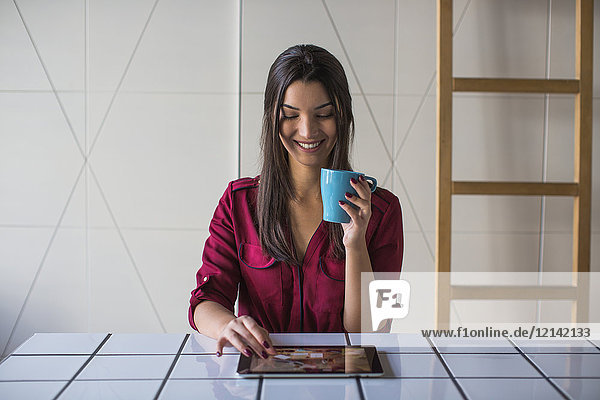 Frau schaut auf Tablet-Computer und lächelt