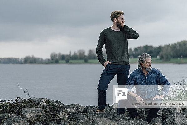Father and son spending time together outdoors  taking a break  sitting on stones