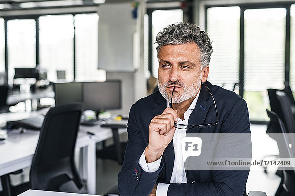 Portrait of serious mature businessman in office thinking