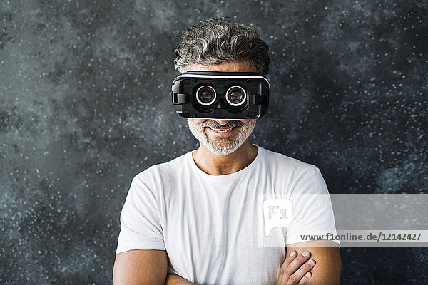 Mature man looking through VR glasses backwards