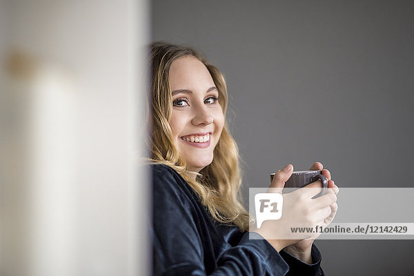 Portrait of laughing young woman with hot beverage
